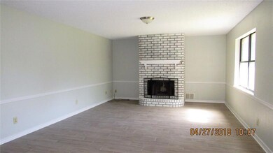 Den with cozy fireplace, new paint, and wood look 