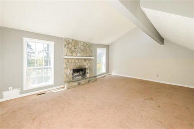 Unfurnished living room featuring carpet floors, a fireplace, and baseboards