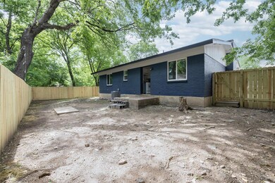 Back of house with brick siding and a fenced backyard