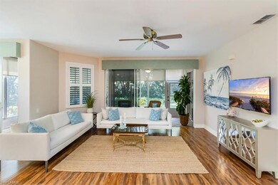 Living room with ceiling fan and rich hardwood flo