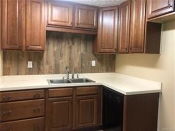 Updated kitchen has lots of cabinets and tile back