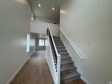Staircase featuring a towering ceiling, wood finished floors, and recessed lighting