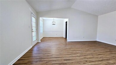 Spare room featuring baseboards, lofted ceiling, a