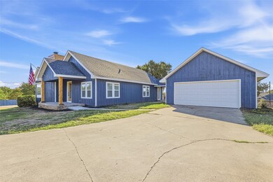 Single story home featuring a chimney, roof with shingles, a front yard, and an outdoor structure