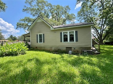 View of home's exterior featuring crawl space, a metal roof, and a lawn