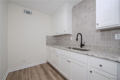 Kitchen featuring white cabinetry, tile backsplash