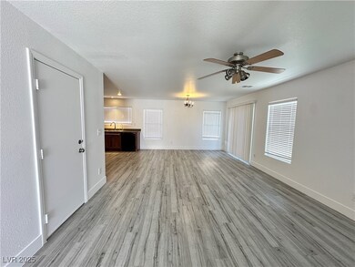 Unfurnished living room with baseboards, light woo