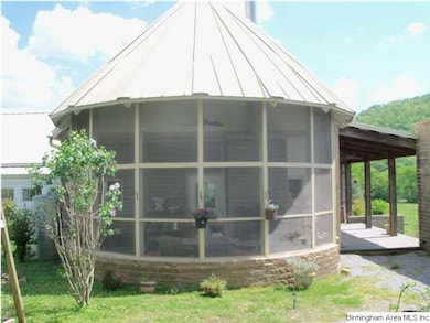 Screened porch with an outdoor fireplace and dinin