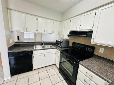 Kitchen with black appliances, tasteful backsplash, white cabinetry, a textured ceiling, and light tile patterned floors