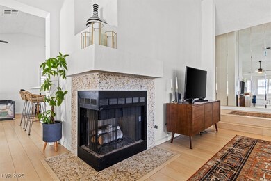 Living room with ceiling fan, a tiled fireplace, h