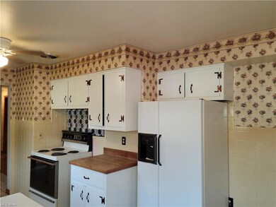Kitchen with white cabinets, ceiling fan, white ap
