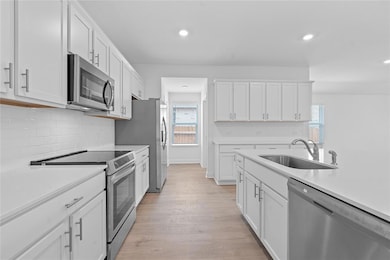 Kitchen featuring stainless steel appliances, lig