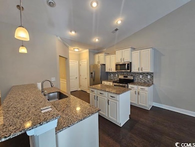 Kitchen with dark wood-type flooring, white cabine