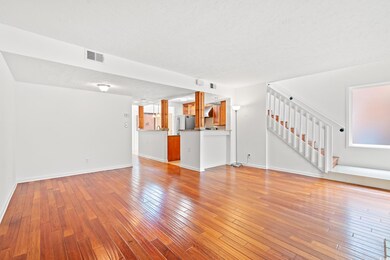 Unfurnished living room with stairway, light wood-style flooring, and a textured ceiling