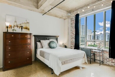 Bedroom featuring a city view and multiple windows