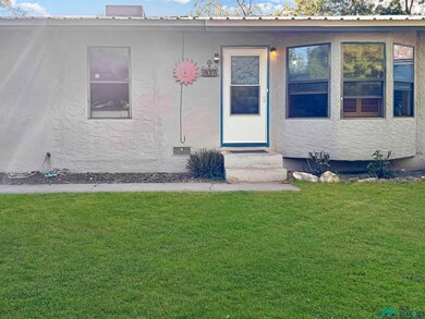 Property entrance with a yard and stucco siding