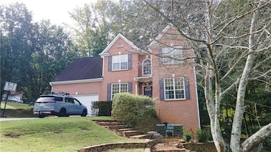 View of front of property featuring brick siding, a front lawn, a garage, and roof with shingles