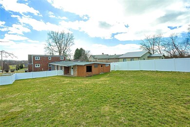 Fenced back yard area with a workshop and attached