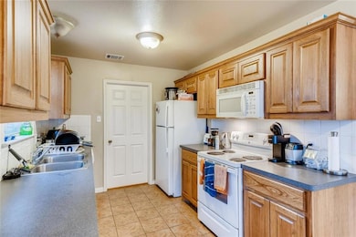 Kitchen with decorative backsplash, a sink, visib