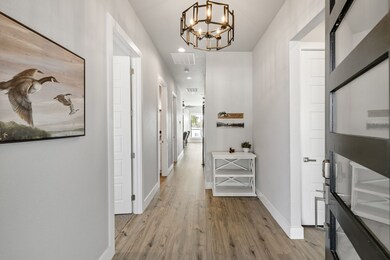 Hall featuring light wood-style flooring, recessed lighting, and a chandelier