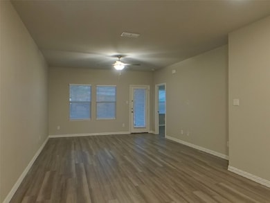 Empty room with wood finished floors and ceiling fan