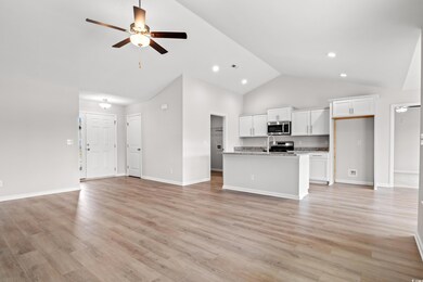 Unfurnished living room featuring baseboards, a si