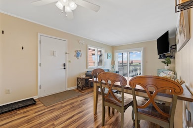 Dining space featuring wood finished floors and ornamental molding