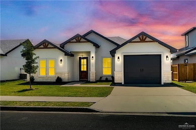 View of front facade with stucco siding, an attached garage, concrete driveway, and stone siding