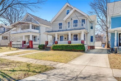 Virtually Staged View of front of property with a front yard, covered porch, a garage, a balcony, and driveway