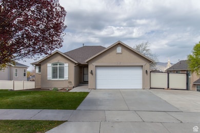 Ranch-style home with concrete driveway, fence, RV access and a garage.