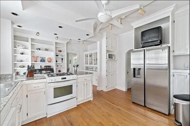 Kitchen featuring sink, white cabinets, light hard