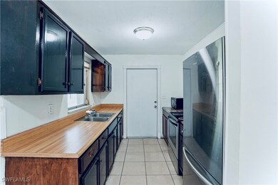 Kitchen with a sink, black microwave, electric ran