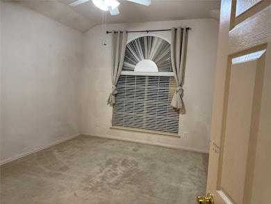 Empty room with carpet, a ceiling fan, and lofted ceiling