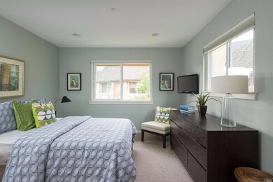 Guest bedroom with two windows and flat screen tel