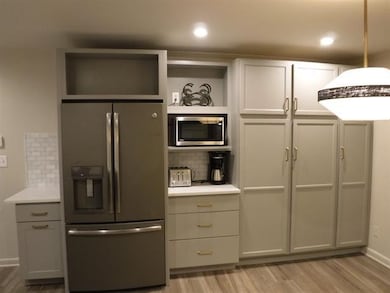 Kitchen with appliances with stainless steel finishes, open shelves, decorative backsplash, light wood-type flooring, and recessed lighting