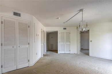 Alternate view of living room with view to bedroom and entry hall as well as a second storage closet