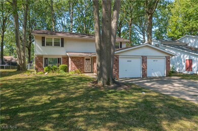 Traditional-style home featuring brick siding, a garage, and driveway