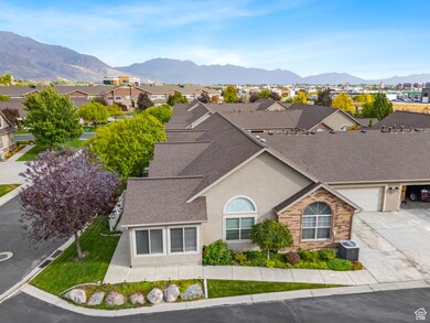View of front facade with a shingled roof, a residential view, stucco siding, a mountain view, and driveway