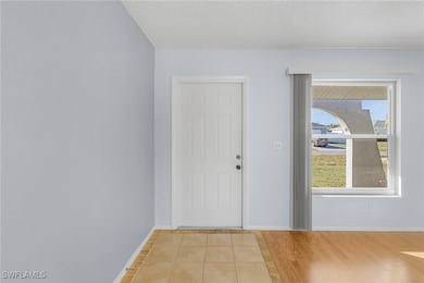 Foyer featuring a textured ceiling and light hardw