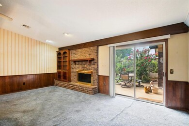 Unfurnished living room with carpet, wood walls, a