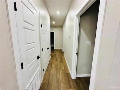 Hall featuring dark wood-style flooring, recessed lighting, and baseboards