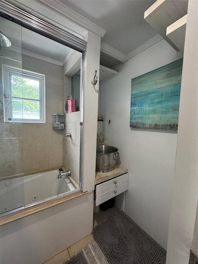 Full bath featuring crown molding, vanity, a combined bath / shower with jetted tub, and tile patterned floors