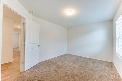 Spare room featuring light carpet and baseboards