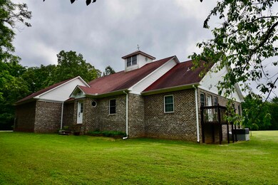 View of property exterior featuring a yard and brick siding