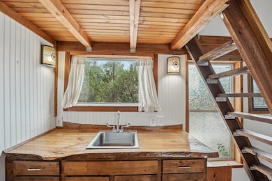 Kitchen with a sink, wooden ceiling with exposed 