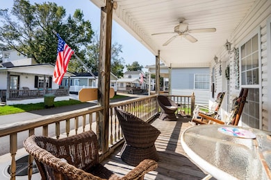 Wooden deck featuring ceiling fan and a porch