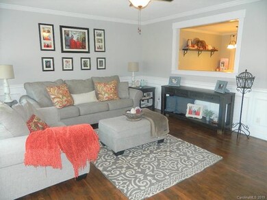 Living room features custom wainscoting and beautiful hardwoods