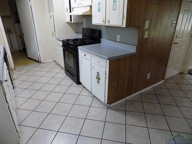 Kitchen with black gas range oven, wooden walls, l
