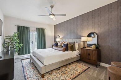 Carpeted bedroom featuring ceiling fan