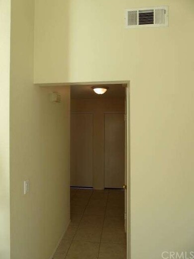 Hallway leading into bedrooms showing more tile on